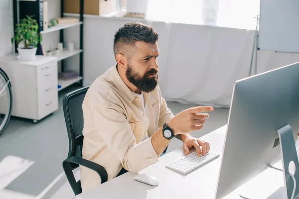 Homem Negócios Concentrado Sentado Mesa Escritório Apontando Para Monitor — Fotografia de Stock