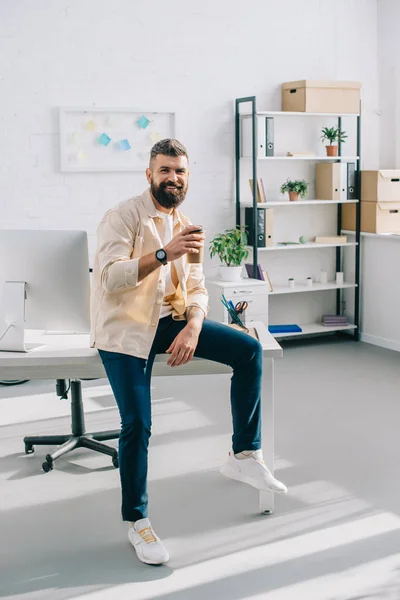 Hombre Negocios Sonriente Sentado Escritorio Oficina Sosteniendo Taza Desechable — Foto de stock gratuita