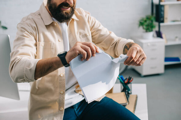 Aggressive boss tearing papers in modern office 