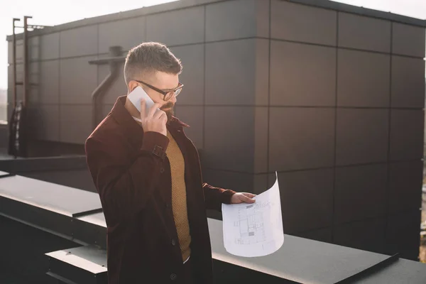 Serious Adult Male Architect Glasses Talking Smartphone Holding Blueprint Rooftop — Stock Photo, Image