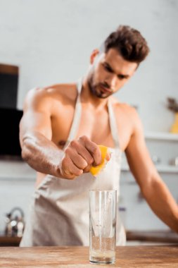 Cam limon sıkarak önlük çıplak göğüslü genç adam görmek