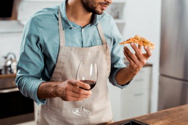 kadeh kadeh şarap ve ev yapımı pizza yiyelim tutan önlük erkekte kırpılmış