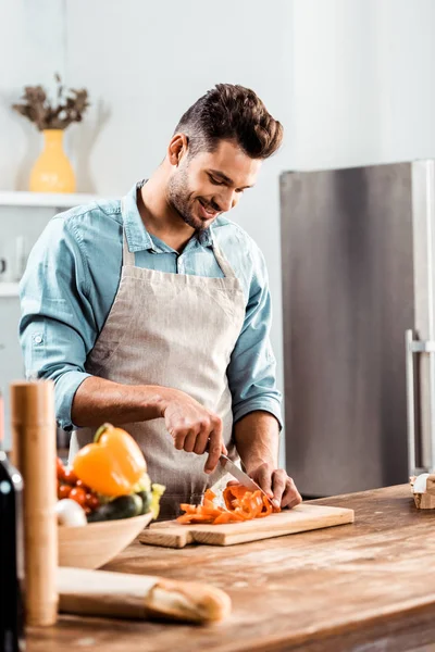 Lächelnder Junger Mann Schürze Der Der Küche Frisches Gemüse Hackt — Stockfoto