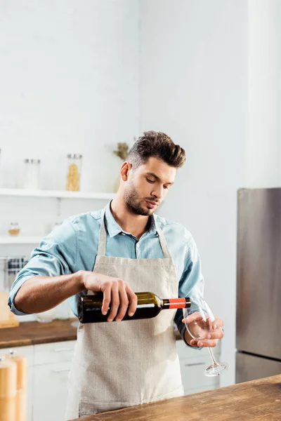 Handsome Young Man Apron Pouring Wine Kitchen — Free Stock Photo