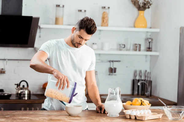 Junger Mann Hält Behälter Mit Cornflakes Und Bereitet Frühstück Küche — Stockfoto