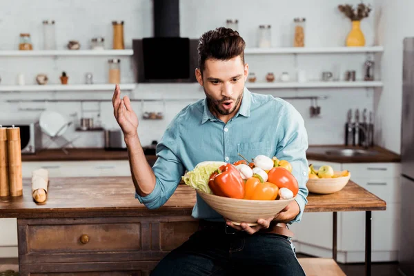 Animado Jovem Segurando Tigela Com Legumes Frescos Cozinha — Fotografia de Stock