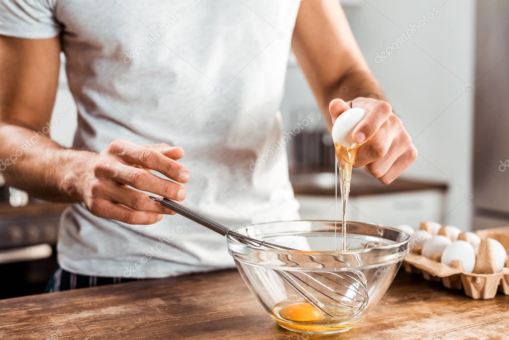 close-up partial view of young man preparing omelette for breakfast