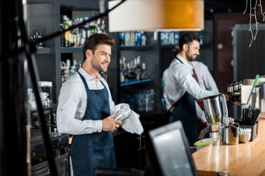 Cam işyerinde bezle ovalamaya yakışıklı gülümseyen barmen