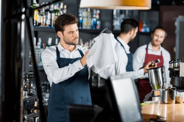 Yetişkin barmen bezle şarap kadehi kadar sürtünme önlük