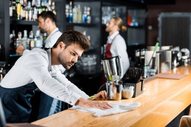 Yetişkin yakışıklı barmen bezle ahşap sayaç Temizleme 