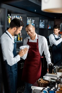 İşyerinde iş arkadaşınız cam parlatma süre ayakta neşeli gülümseyen barmen