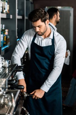 yakışıklı barista kahve makinesi işyerinde kullanarak önlük