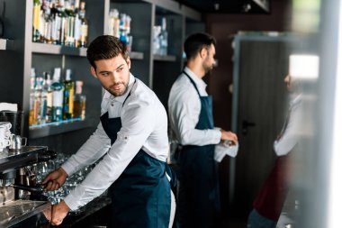 Yetişkin yakışıklı barista kahve makinesi işyerinde kullanarak önlük