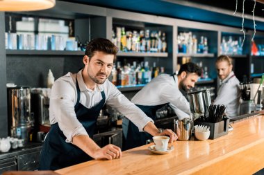 Yetişkin yakışıklı barista kahve ahşap sayaç ile önlük