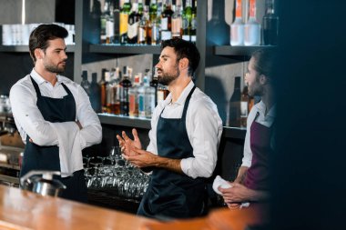 barmen ayakta ve işyerinde iletişim önlük içinde 