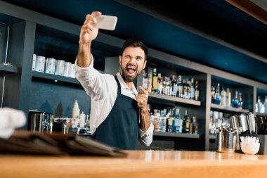 Smartphone ve alma selfie ile ayakta barmen çubuk 