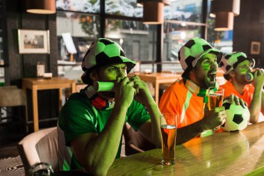 Futbol hayranları vuvuzelas içinde üfleme ve çığlık içinde bar