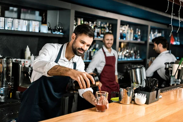 Smiling Bartender Pouring Cocktail Glass Wooden Counter — Stock Photo, Image