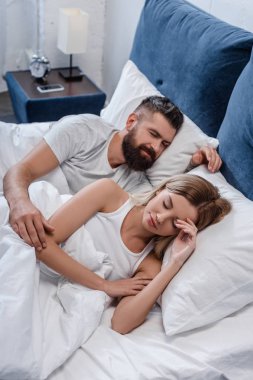 Genç ve güzel kız büyük beyaz yatakta sabah uyku sakallı