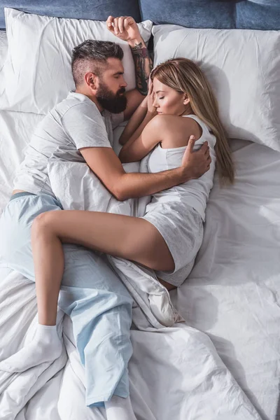 美丽的夫妇拥抱和睡在明亮的卧室在早晨 — 图库照片