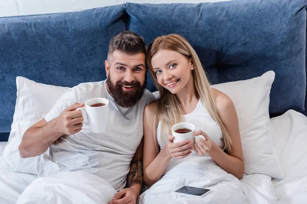 Ευτυχισμένο Ζευγάρι Ξαπλωμένη Στο Κρεβάτι Και Πίνοντας Τον Καφέ Πρωί — Φωτογραφία Αρχείου