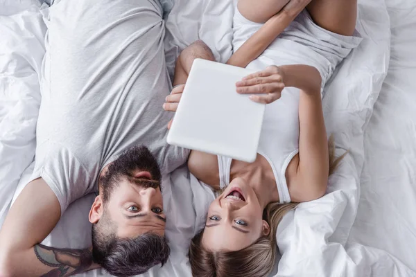 Surprised Couple Lying Bed Looking Digital Tablet — Free Stock Photo