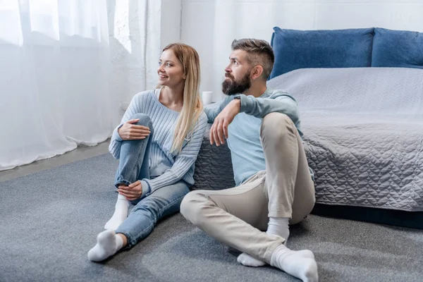 Feliz Joven Pareja Sentada Suelo Mirando Ventana Dormitorio Azul — Foto de Stock