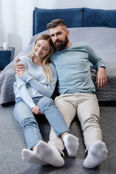 Hombre Guapo Sentado Suelo Abrazando Joven Atractiva Dormitorio Azul — Foto de stock gratuita