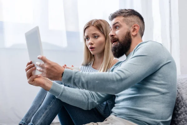 Couple Sitting Floor Digital Tablet Looking Surprised — Stock Photo, Image