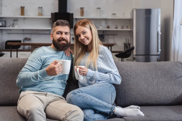 Casal Feliz Sentado Sofá Roupas Casuais Com Bebidas — Fotos gratuitas