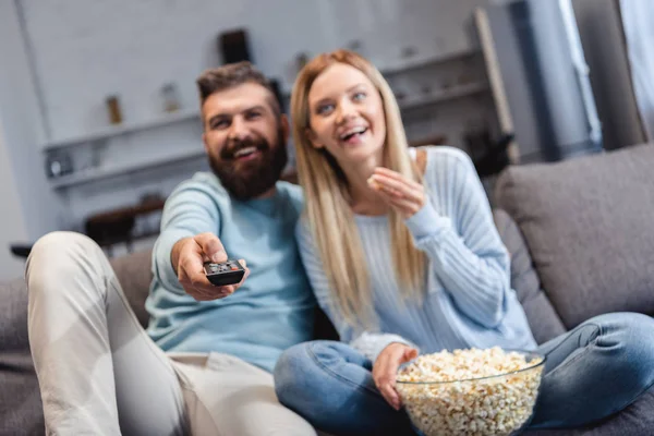 幸せなカップルのポップコーンが付いているソファーの上に座って 映画を見て — ストック写真