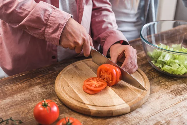 Vista Recortada Del Hombre Cortando Tomate Sobre Tabla Madera Cocina —  Fotos de Stock