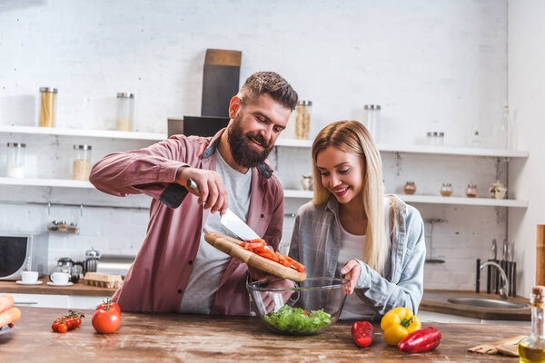 Husband and wife adding ingredients in salad 