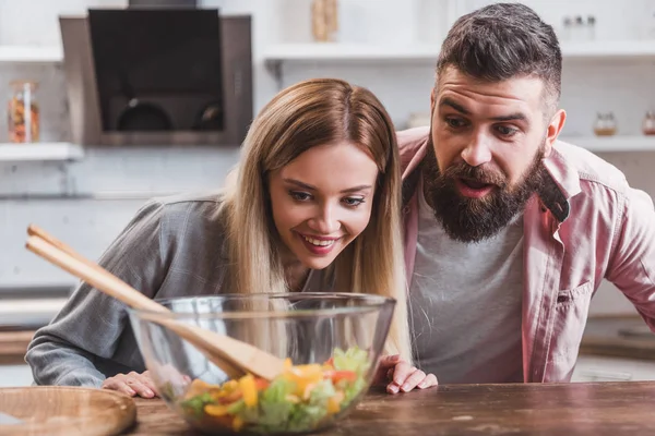 Surprised Cheerful Couple Looking Salad Glass Bowl Kitchen Table — Free Stock Photo