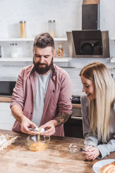 young couple preparing breakfast together at kitchen