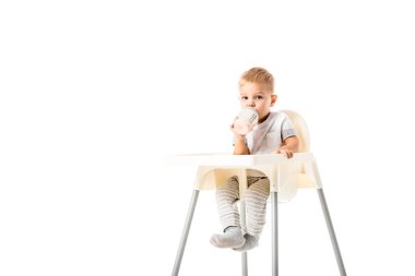 oturma sandalyesi ve bebek şişe üzerinde beyaz izole içme çok güzel yürümeye başlayan çocuk