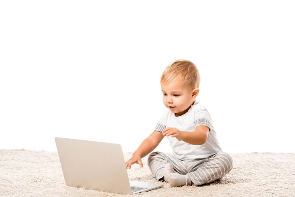 Bambino Sorridente Seduto Con Laptop Tappeto Isolato Bianco — Foto stock gratuita