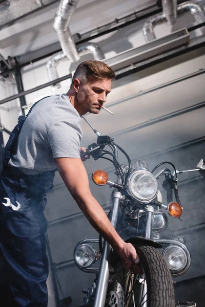 Smoking Adult Mechanic Overalls Checking Motorcycle Tire Garage — Stock Photo, Image