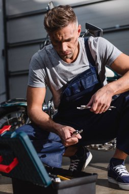 yakışıklı tamirci anahtarı motosiklet garajda sabitleme için malzeme çekme