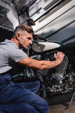 yakışıklı yetişkin makinist motosiklet motoru garajda sabitleme