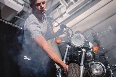adam sigara içilmeyen ve garajda kontrol motosiklet ön tekerlek