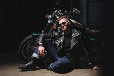 motosiklet garaj tarafından ayakta güneş gözlüğü yakışıklı motorcu