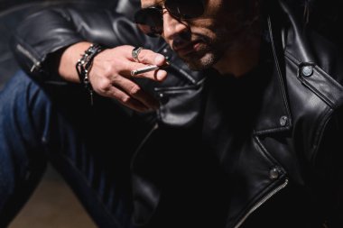 yakışıklı siyah güneş gözlüğü ve motosiklet üzerinde eğilerek deri ceket 
