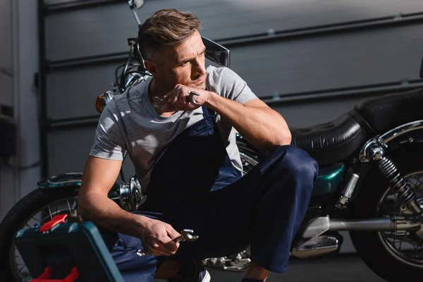 Serious Mechanic Holding Wrenches Sitting Toolbox Garage — Free Stock Photo