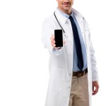 Обрізаний вид лікаря, що тримає смартфон з порожнім екраном ізольовано на білому