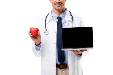 Doktor kalp modeli ve laptop boş ekran ile tutarak kısmi görünümünü izole üzerinde beyaz, kalp sağlık kavramı