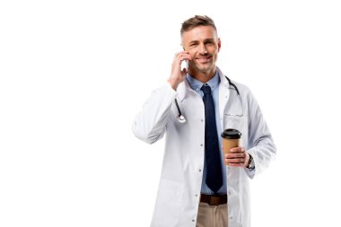 kameraya bakarak, kahve holding ve üzerinde beyaz izole Smartphone cep telefonu ile konuşmak doktor