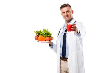 yakışıklı Doktor biber ve taze sebze izole beyaz, sağlıklı beslenme kavramı üzerinde saçtan tutarak