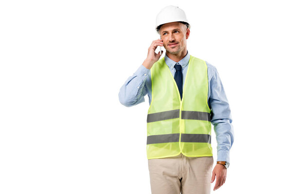 handsome engineer in helmet talking on smartphone isolated on white