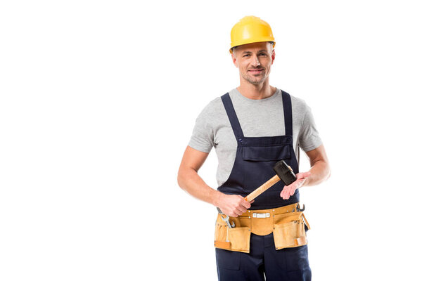 строитель в шлеме смотрит в камеру и держит молоток изолированным на белом
